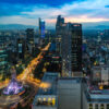 A breathtaking view of Mexico City at night, featuring the iconic Angel of Independence monument illuminated by vibrant lights, capturing the lively atmosphere and bustling nightlife of the city